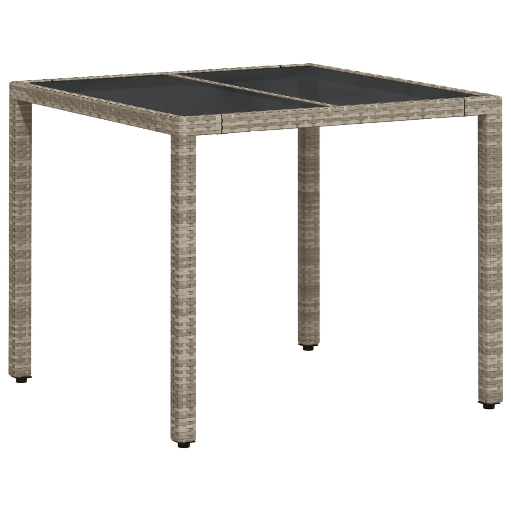 Garden table with light grey glass top and woven resin