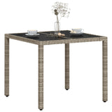 Garden table with light grey glass top and woven resin