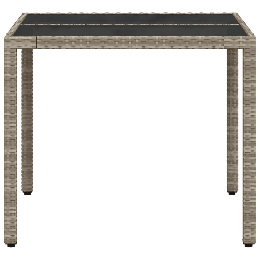 Garden table with light grey glass top and woven resin